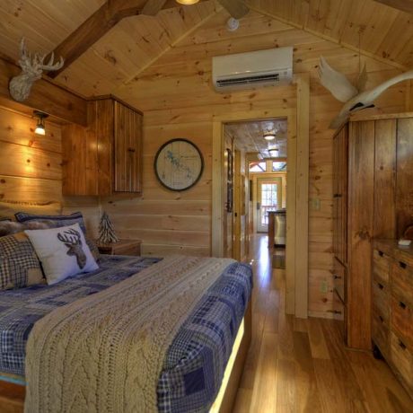 Cabin interior with bed, cabinets, and hallway