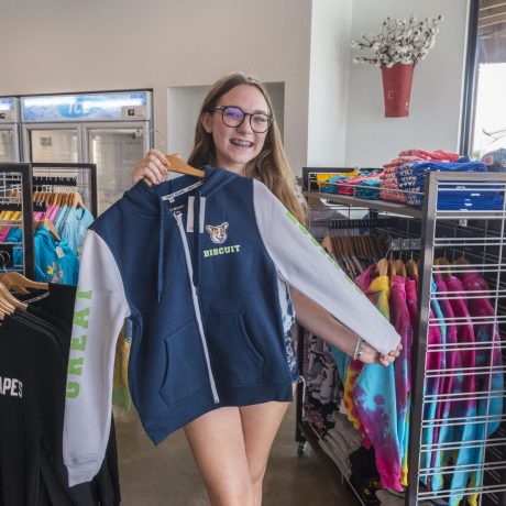girl trying on sweater at camp store at Great Escapes RV Resorts Bryan College Station