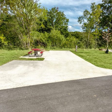 empty RV site with concrete pad and picnic table at Great Escapes RV Resorts Bryan College Station